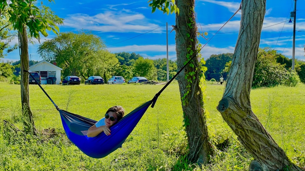 A woman hanging in a camping hammock